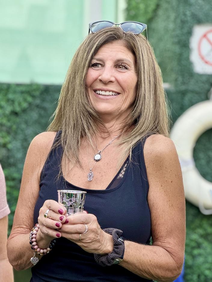 A participant holding a kiddush cup during a program gathering