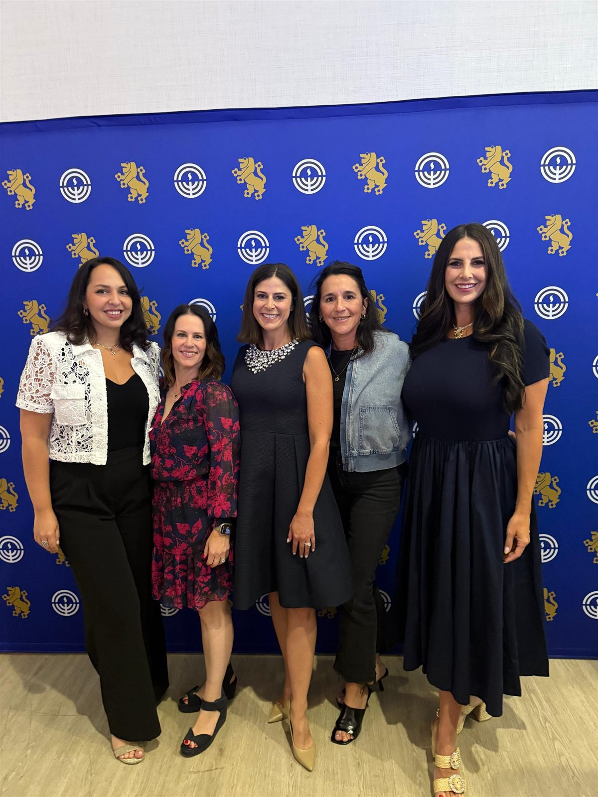 Five National Young Leadership Cabinet members in front of a Jewish Federation backdrop